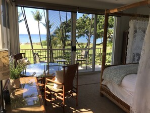 A bedroom with a large sliding glass door leading to a balcony with a view of the ocean and palm trees. - RARE, GATED, PRIVATE BEACHFRONT HOME! PRIVATE POOL, 6 BEDS 6 BATHS (Kihei)