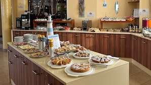 Zona de bufé con diferentes opciones de comida y una estación de café.