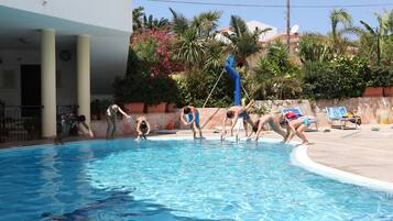 A swimming pool with people engaging in water activities.