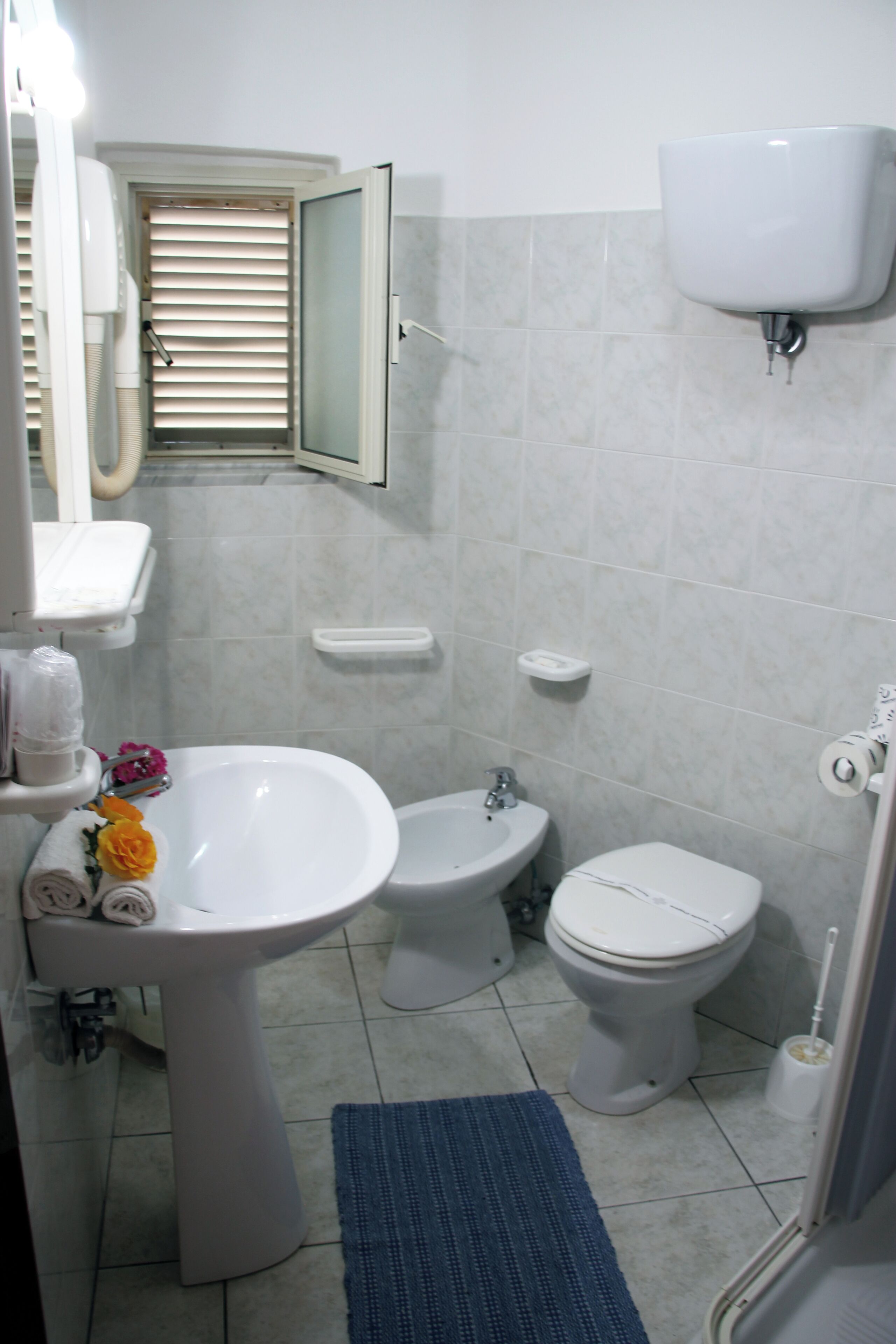 Un baño con lavabo, bidé, inodoro y espejo.