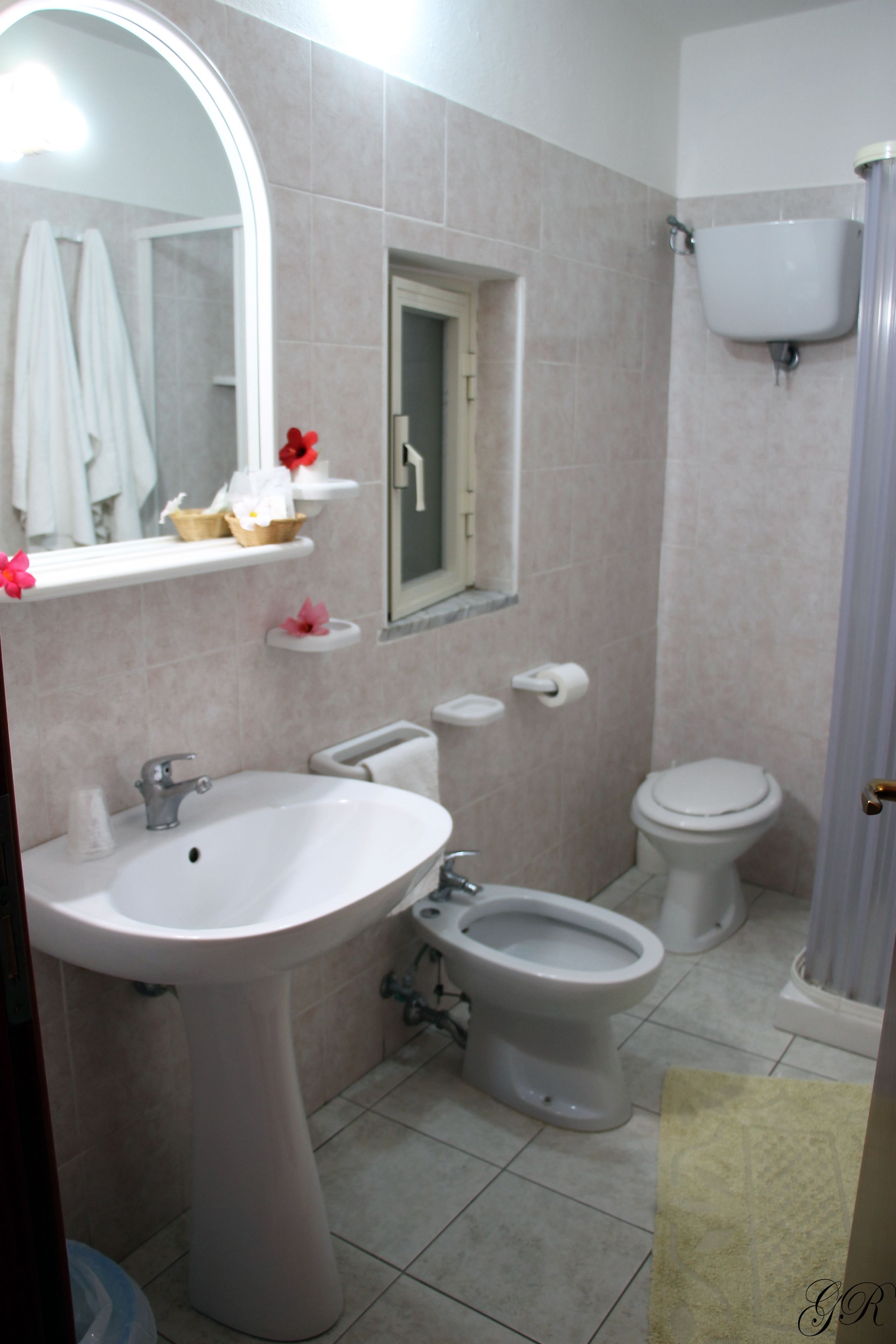 Ein Badezimmer mit Waschbecken, Bidet, Toilette und Spiegel.