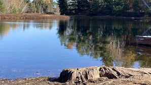 A calm lake with a dock, surrounded by trees and a clear sky. - Comfortable 3 Bedroom Cabin On the Shores of Lake Chippewa Flowage in Hayward WI (Hayward)