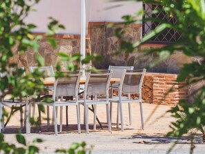 Sit and dine in a serene outdoor setting with a table and chairs.