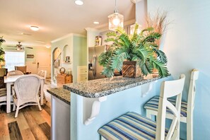 Enjoy a casual dining experience in this modern kitchen with a granite countertop, stainless steel appliances, and a cozy dining area.