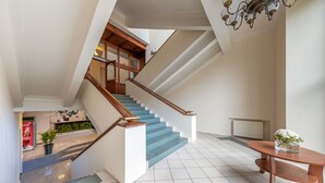 A modern staircase with wooden handrails and blue steps, leading to an upper floor. - Hotel Simple Plus (Vilnius)