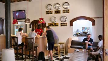 A bar area with wooden furniture, a central bar counter, and multiple clocks on the wall.