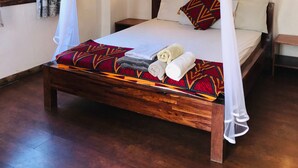 A bed with a canopy, pillows, and towels. - Cafe Central (Mozambique Island)