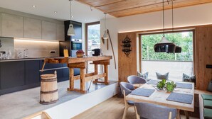 Une cuisine moderne avec une table et des chaises en bois, une grande fenêtre offrant une belle vue et un tonneau rustique.