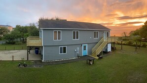 A two-story house with a covered deck and a staircase leading to a second level. - Beach House Rental Duck, NC (Duck)