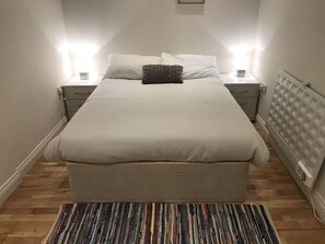 Cozy retreat with a large bed, bedside tables, and a colorful rug.