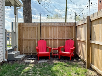 Fenced side yard with seating and twinkle lights