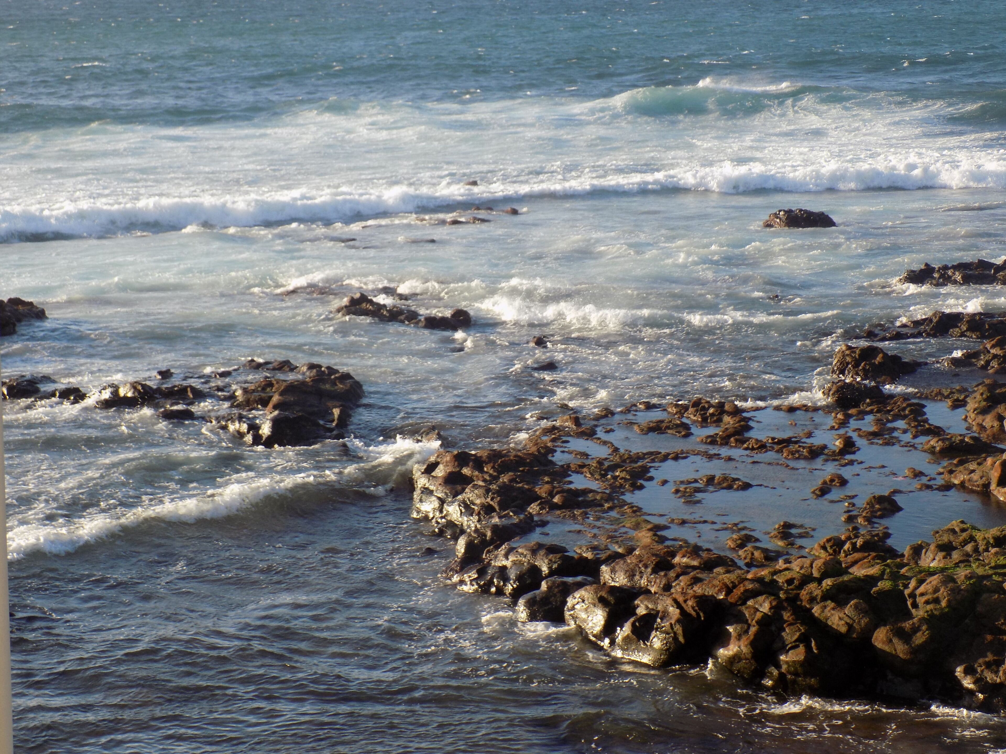 A rocky shoreline with waves crashing against the rocks.
