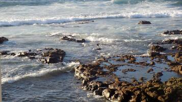 A rocky shoreline with waves crashing against the rocks.
