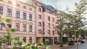 Un hotel amb una façana clàssica, moltes finestres i un gran rètol que diu 'HOTEL'.