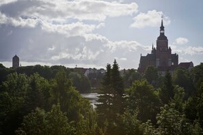 A historic building with a prominent tower and a river in the foreground. - Double room standard - Hotel Am Jungfernstieg (Stralsund)