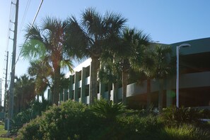 A parking garage with multiple levels, surrounded by palm trees and greenery. - WOW - SOME SUMMER DATES AVAILABLE  BEACH SERVICE - CLEAN - OCEANFRONT - AMAZING (Fort Walton Beach)