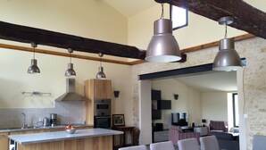 Cocina moderna con armarios de madera, una isla central e iluminación colgante.
