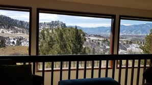 Una habitación con ventanas amplias que ofrecen vistas a un paisaje montañoso.