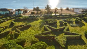 Une propriété située sur la côte, dotée de jardins bien entretenus, d’une plage et offrant une vue sur la mer.