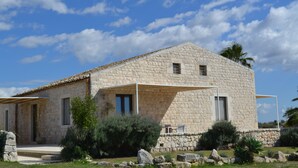 A stone building with a sloped roof, a covered porch, and a stone wall surrounding the property. - MAESTRALE 1 bedroom apt 2/4 sleeps  with Pool - Modica - Sicily (MODICA)