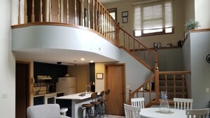 A spacious living area with a kitchen, dining table, and a wooden staircase. - 2 Bedroom, 2 bath home in The Galena Territory.  Close to Eagle Ridge Resort (Galena)