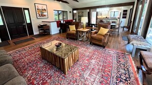 A spacious living room with a large rug, a coffee table, and leather sofas. - Stillwater River Escape, Amazing Views, Secluded! (Whitefish)