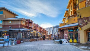 Una calle nevada con edificios que presentan balcones y una variedad de estilos arquitectónicos.