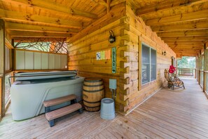 A wooden cabin with a hot tub, wooden barrels, and a covered porch. - True Log Cabin, Hot tub, Fire Pit, Easy access and close to downtown. (Gatlinburg)