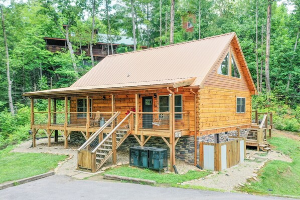 A wooden cabin with a porch, a staircase, and a small deck. - True Log Cabin, Hot tub, Fire Pit, Easy access and close to downtown. (Gatlinburg)