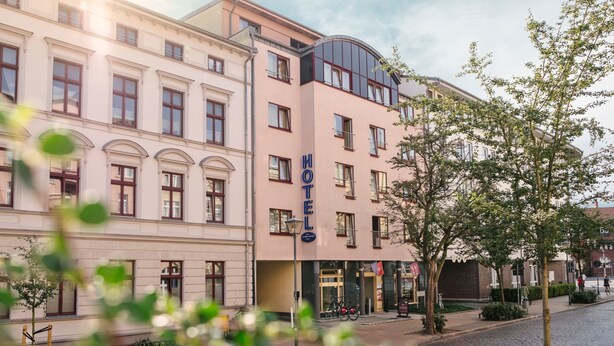 Et hotel med en klassisk facade, flere vinduer og en markant indgang.
