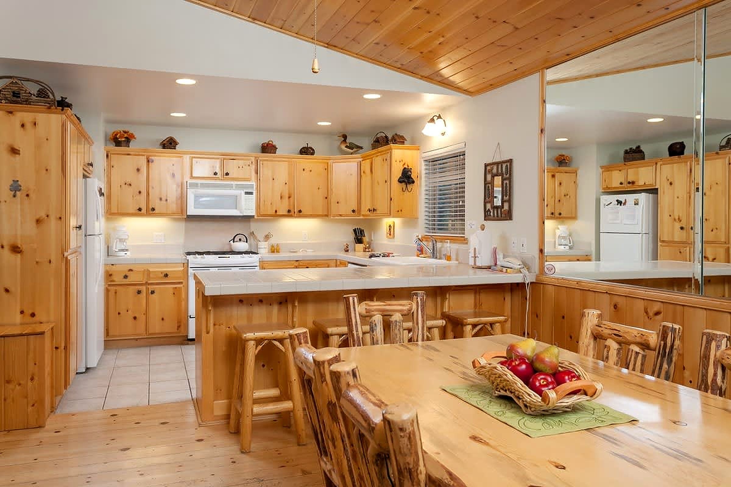 Une cuisine avec des meubles en bois, un îlot central et une table à manger avec des chaises.