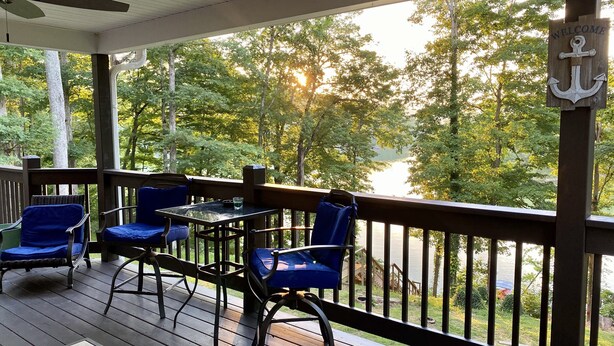 A covered deck with outdoor seating and a view of a lake. - Lakefront home near Mammoth Cave (Mammoth Cave)