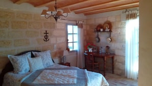 A bedroom with a bed, a desk, and a window.