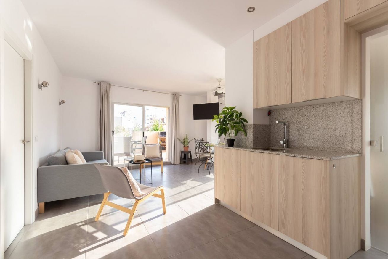 A modern kitchen with wooden cabinets, a built-in stove, and a countertop.