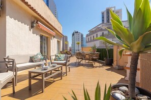 An outdoor patio area with a sofa, chairs, and a table.