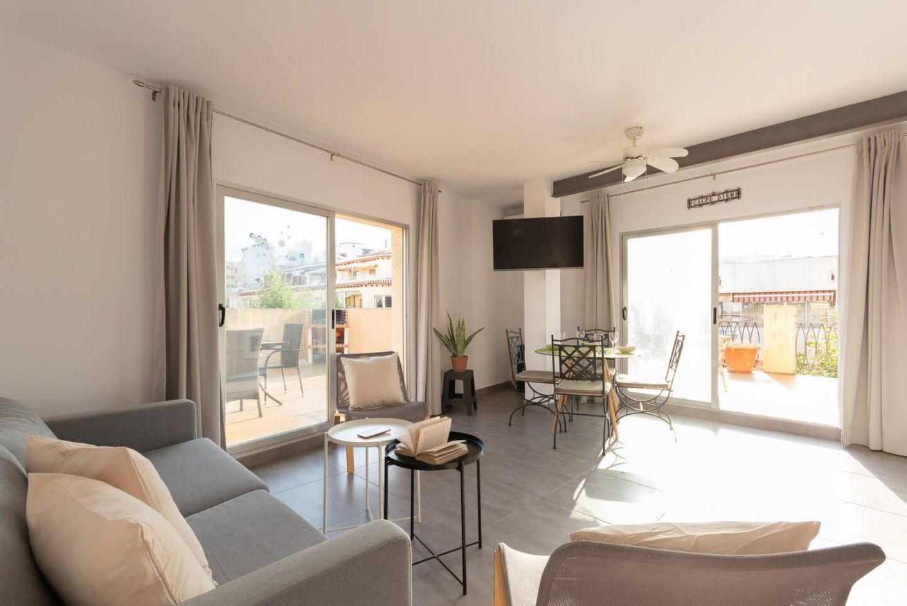 Een moderne woonkamer met een bank, een kleine tafel en een eethoek met stoelen.