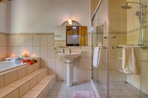 Ein modernes Badezimmer mit einer Duschkabine, einem Waschbecken auf Säule und einem Waschtisch mit Spiegel.