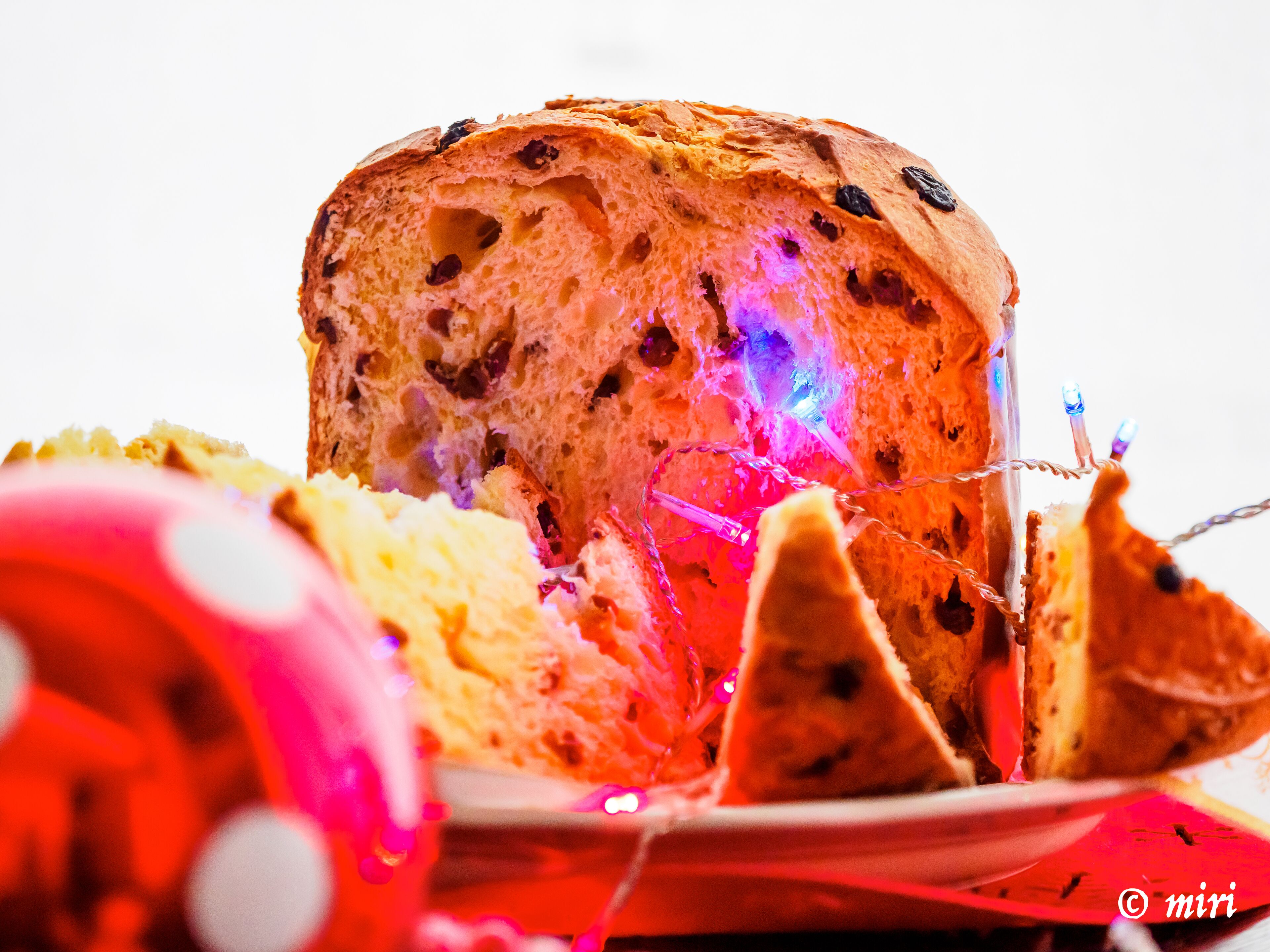 Una hogaza de pan con pasas y una guirnalda decorativa de luces.
