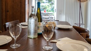 A dining table with two wine bottles, two wine glasses, and a glass water bottle. - Villa La Pavona Luxury Collection (Monterosso al Mare)