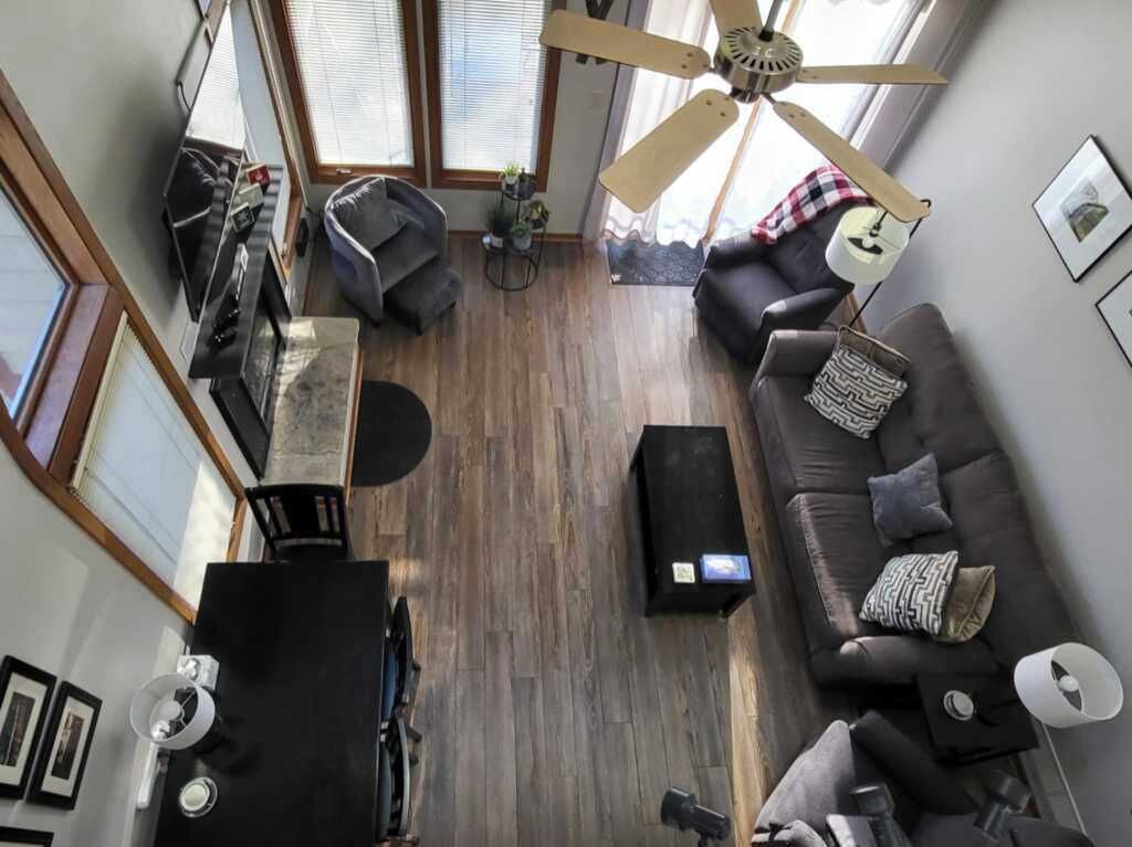 Un salon avec un canapé, une table basse, un téléviseur et un ventilateur de plafond.