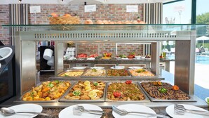 A buffet with various food options, including salads, meats, and desserts, displayed on trays. - Aktinia (Nessebar)