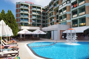 Un hôtel doté d’une piscine, d’un espace extérieur aménagé et d’un bâtiment avec des balcons.