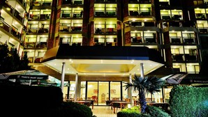 A multi-story hotel with illuminated balconies and a covered entrance area. - Aktinia (Nessebar)