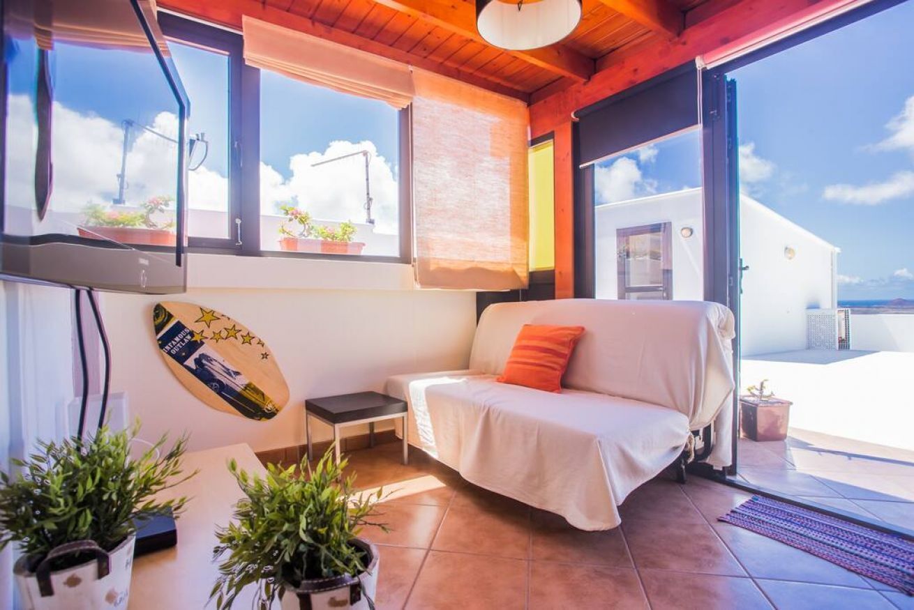 Une pièce chaleureuse avec un canapé, une petite table et des plantes en pot.