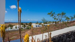 A coastal landscape with white buildings, a clear blue sky, and a view of the sea. - Pico Colorado de Soo (Soo)