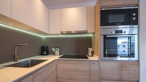 A modern kitchen with a Bosch microwave, oven, and a coffee maker on the counter.