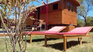 A wooden cabin with two lounge chairs and a small table. - Roulotte La Nanouche (Le Cailar)