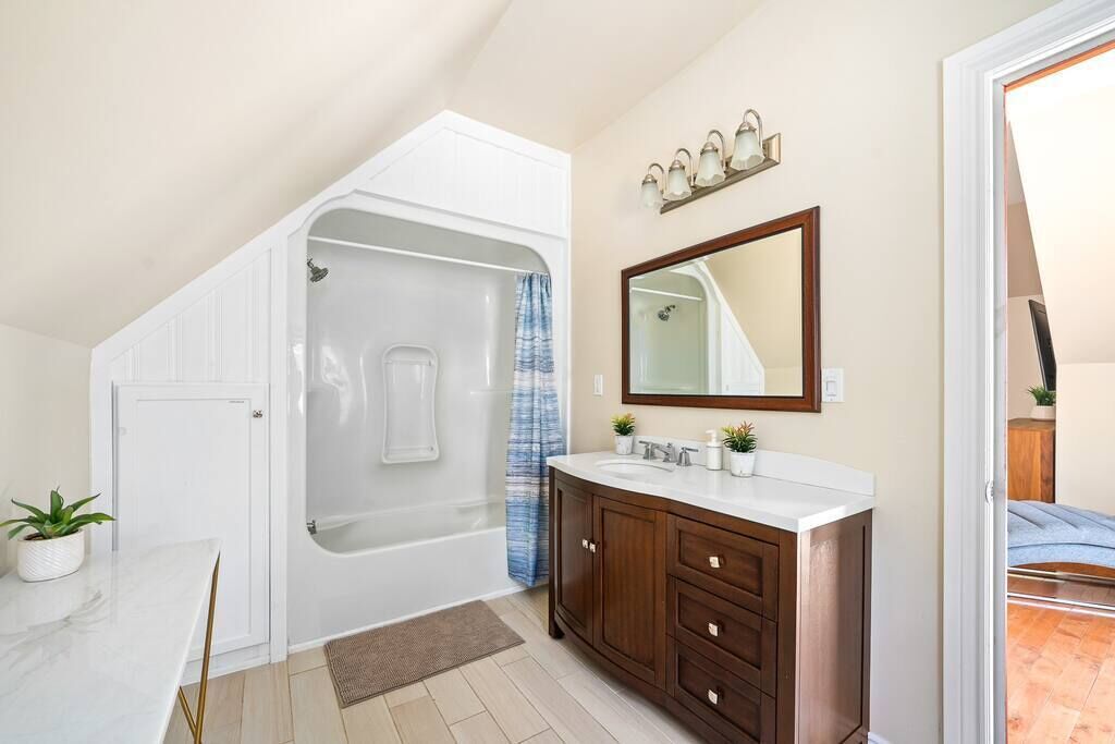 Une salle de bain avec une baignoire, un meuble-lavabo et un miroir.