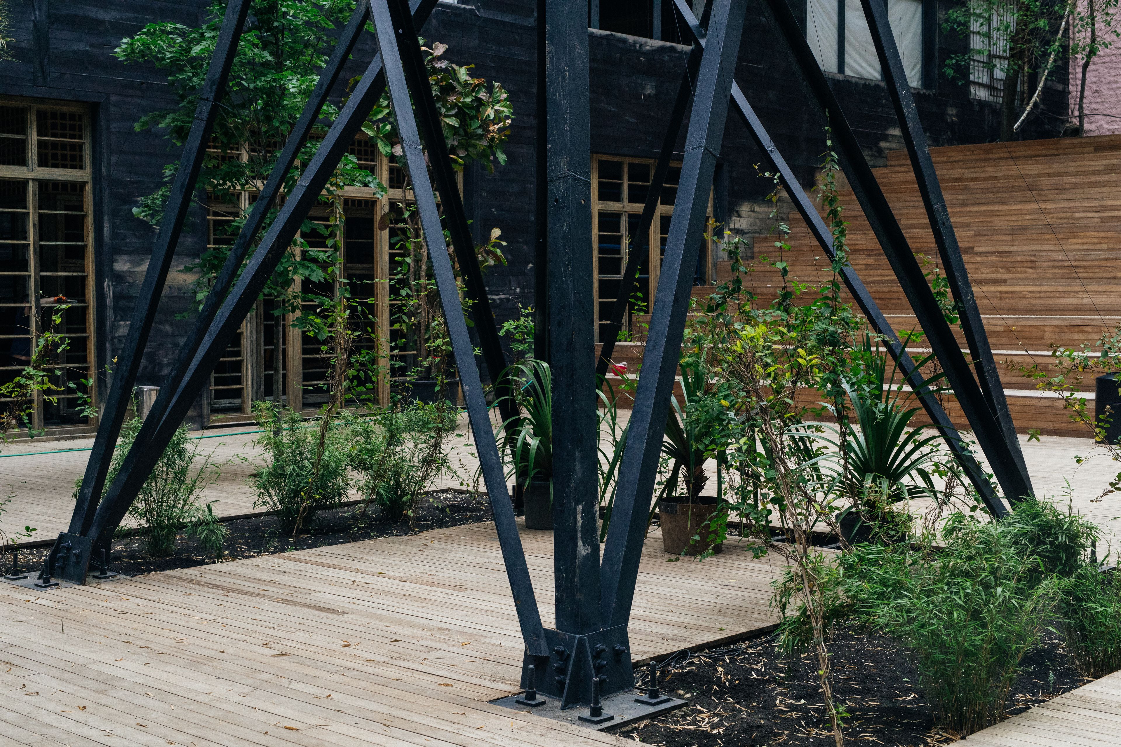Een modern gebouw met een houten terras en metalen constructie.