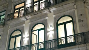 A multi-story building with arched windows and balconies with wrought iron railings. - Santa Catarina FLH Suites (Porto)